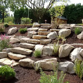 A Greenhaven Landscapes design customer's Vancouver WA rock wall and stone stairway along a pathway