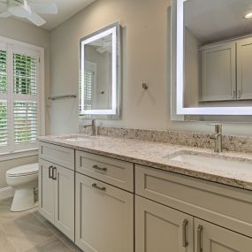 Beautiful vanity and lighted mirrors in bathroom remodel.