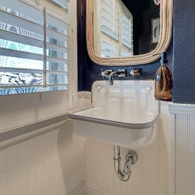 A console wall-mounted sink adds style and space to this small bathroom in Wrightsville Beach.