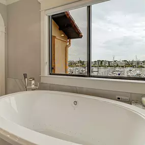 Reconfigured bathroom by moving the shower and adding the free-standing tub. Lovely looking over the marina.