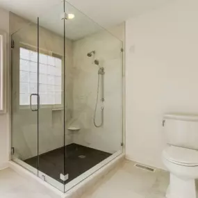 Full height glass enclosure around a large tile shower in Carolina Beach.