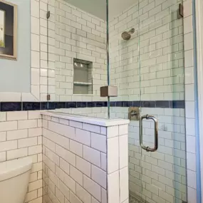 Decorative tile, a knee wall, and a frameless glass shower enclosure create a brighter, inviting shower in Wilmington.