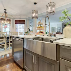 The natural wood cabinets and stainless apron sink make for a nice contrast in a white kitchen