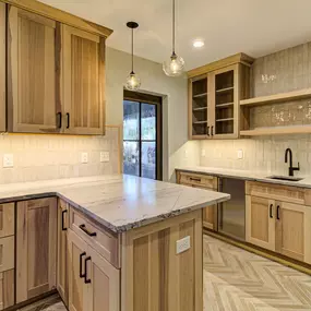 Hickory Cabinets, floating shelves, and rustic tile backsplash