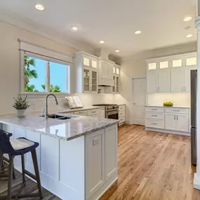 White Shaker Cabinets, Quartz Countertops and White Wave Tile Backsplash created a fresh look in a Carolina Beach home
