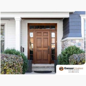 Beautiful entry door surrounded by decorative fixed windows.