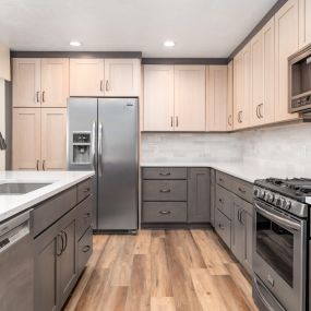 Two-toned kitchen cabinets, subway backsplash tile, LVP flooring, countertops, sink, appliances