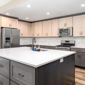 Two-toned kitchen cabinets, subway backsplash tile, LVP flooring, countertops, sink, appliances