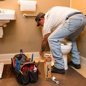 Outer Banks plumber repairing a leaky toilet.