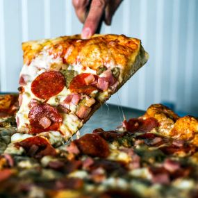A cheesy slice of supreme pizza at Corolla Pizza & Deli in Corolla, North Carolina.