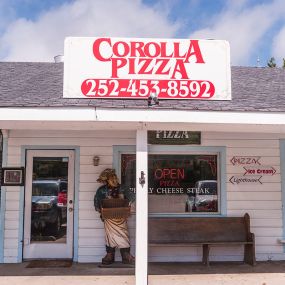 Corolla Pizza & Deli store front next to Winks Gas Station in Corolla, NC.