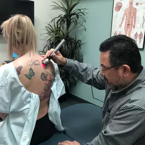 Dr. Prieto at Prieto Chiropractic & Spinal Decompression Center in Northern Orange County, giving a patient a cold laser therapy treatment on their shoulder.